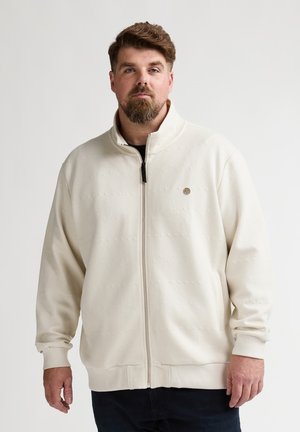 Weiße Jacke mit Reißverschluss, strukturierter Oberfläche, Stehkragen und Frontreißverschluss. Verziert mit einem runden Logo auf der Brust. Weicher Stoff.