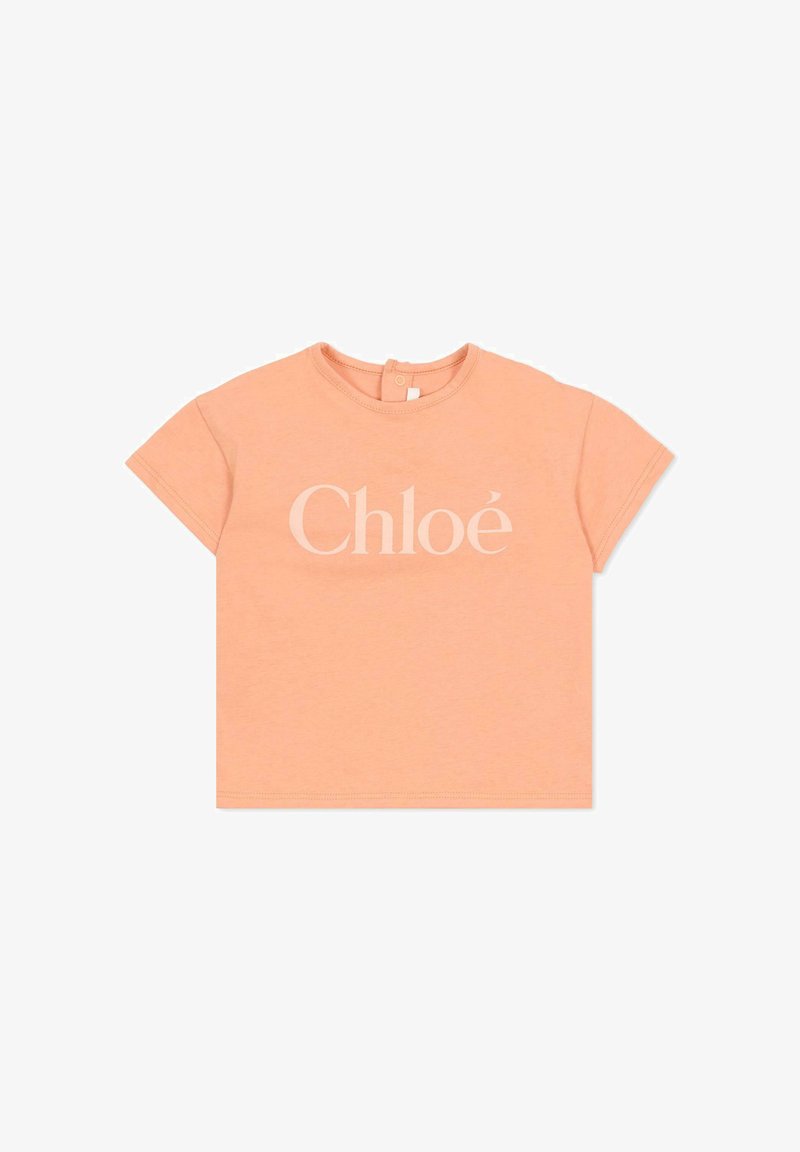 Miękka, brzoskwiniowa koszulka z krótkim rękawem dla malucha, z logo "Chloé" nadrukowanym z przodu w jasnobeżowym kolorze oraz zapięciem na guziki z tyłu.