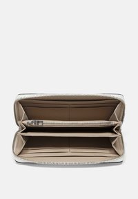 Schwarze und cremfarbene Reißverschlussbörse mit glattem Lederfinish. Verfügt über mehrere Kartenfächer, ein Reißverschlussfach und organisierte Sektionen.