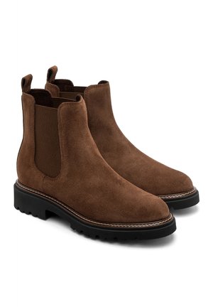 Paar braune Chelsea-Stiefel aus Wildleder mit schwarzen robusten Sohlen und elastischen Seitenpaneelen auf weißem Hintergrund.