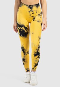 Geel leggings met een zwart abstract patroon, hoog in de taille, met een gladde textuur en gemaakt van rekbaar, ademend materiaal.