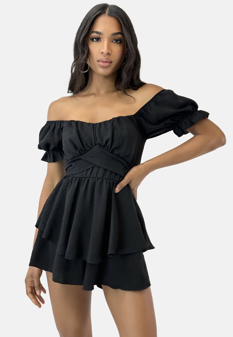 Top nero off-shoulder con maniche a volant, corpetto aderente e orlo peplum a strati. Tessuto morbido e leggero.