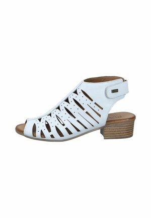 White leather open-toe sandal with cut-out patterns, low stacked wooden heel, and ankle strap with Velcro closure.