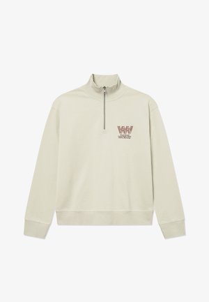 Lys beige langermet genser med ribbede mansjetter og nederkant, kvart glidelås, og liten rød logo og tekst på venstre bryst.