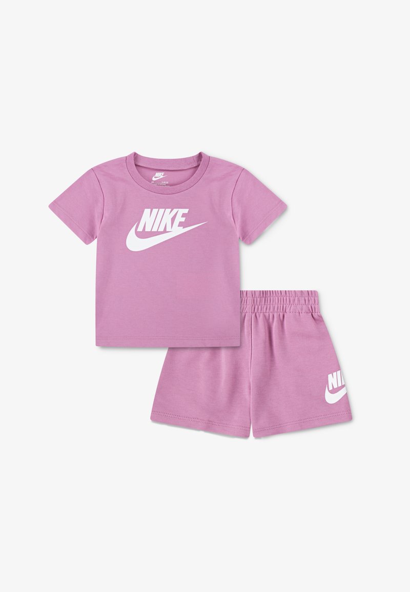 Conjunto de camiseta de manga corta y pantalones cortos de algodón rosa. La camiseta presenta el logo blanco de Nike; los pantalones cortos tienen una cinturilla elástica con el logo a juego.