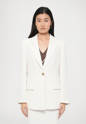 Hvid blazer lavet af et tekstureret stof, med en enkelt guldknap, to forlommer og en skræddersyet pasform med let udvidede ærmer.