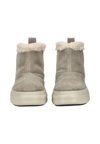Beige Wildleder-Ankle Boots mit einem weichen cremefarbenen Kunstfellkragen und einer dicken weißen Sohle, ausgestattet mit einer Zuglasche an der Rückseite für einfaches An- und Ausziehen.