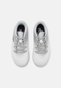 White athletic shoes with a smooth texture, grey laces, and a speckled silver upper. Rounded toe and cushioned interior for comfort.