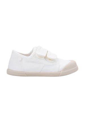 Zapatilla de lona blanca con dos correas de Velcro, suela de goma beige y punta redonda. Diseño minimalista con textura contrastante en la suela.