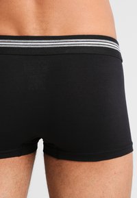 Schwarze Boxershorts mit weicher Textur, enganliegendem Design und elastischem Bund in kontrastierendem grau gestreift.