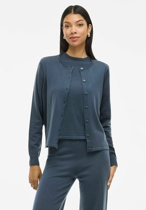 Donkerblauwe cardigan set met een ronde halslijn, knoopsluiting aan de voorkant en lange mouwen, gemaakt van een zachte stof met een gladde textuur.