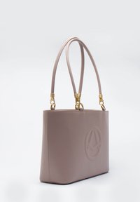 Borsa tote in pelle rosa chiaro con hardware dorato, dotata di manici allungati e logo in rilievo sulla parte anteriore. Tessuto liscio.