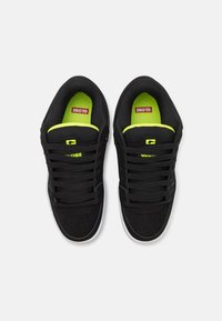 Sneakers neri con una finitura testurizzata, dotati di una suola interna gialla brillante e marchio GLOBE. Design con lacci, suola in gomma e punta arrotondata.