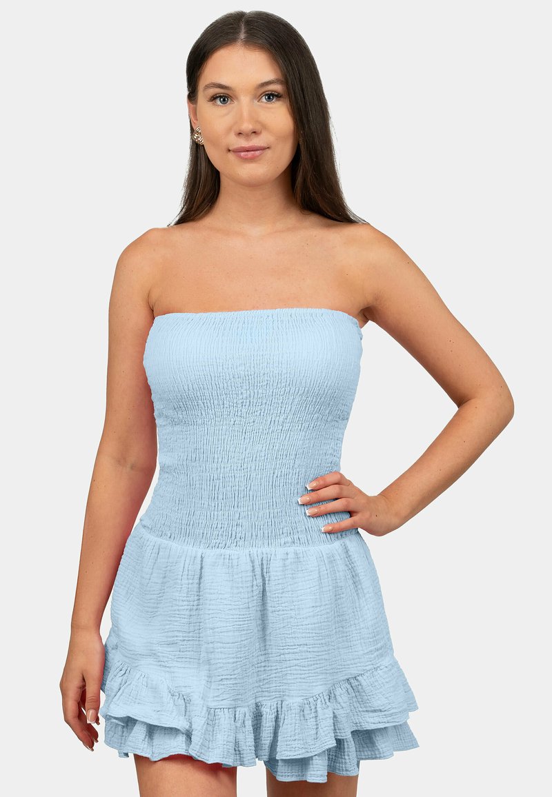 Robe bleu clair sans manche avec un corsage smocké, un ourlet volanté et un tissu texturé. Ajustée en haut, elle s'évase en bas.