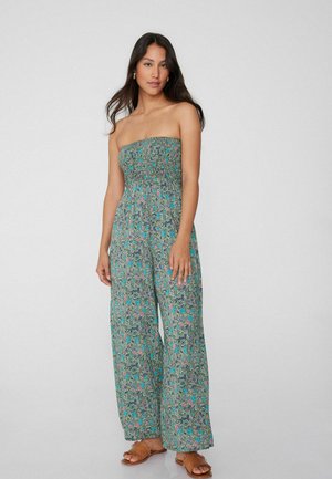 Mono verde sin tirantes con patrón floral, que presenta un cuerpo fruncido y piernas anchas y fluidas de tejido ligero.