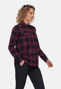 Camicia flanella a quadri bordeaux e nera con chiusura a bottoni sul davanti, due tasche sul petto e colletto. Maniche lunghe con polsini a bottoni.