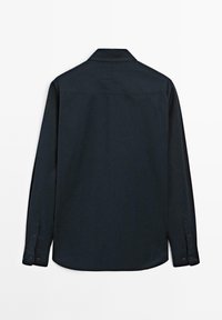 Camicia a maniche lunghe blu navy scuro vista dal retro, con colletto dritto e polsini abbottonati.