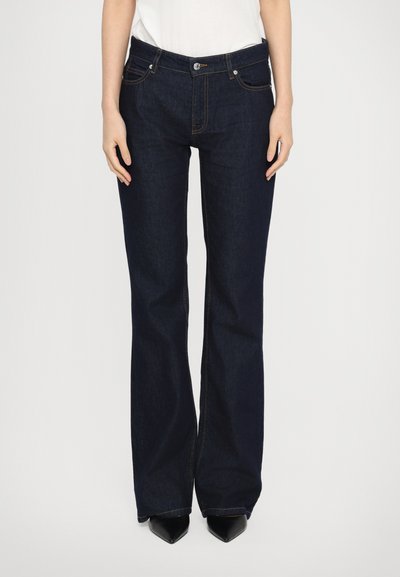 Jeans a campana di un blu scuro con una superficie in denim liscia, caratterizzati da cuciture arancioni, tasche frontali e chiusura con bottone metallico.