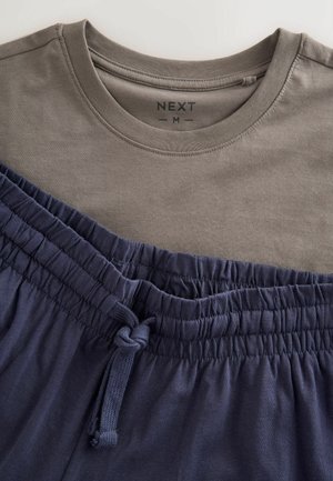 Brun crew neck t-shirt i størrelse medium kombineret med marineblå shorts med elastik i taljen og et bundet snørebånd.