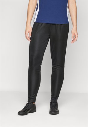 Black athletic pants with a smooth, shiny texture. Features fitted design and contrasting white side stripes. Paired with black footwear.