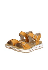 Orangefarbene Leder-Sandalen mit verstellbaren Riemen, einer gepolsterten Innensohle und einer weißen Sohle mit roten Akzenten. Mit Schnallenbeschlägen.