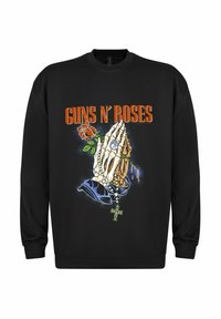 Zwarte sweatshirt met een grafisch ontwerp van een skelethand met een roos, kralen en een kruis, met de tekst "GUNS N’ ROSES" in oranje.