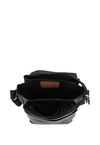 Bolso de hombro de cuero negro con cierre de cremallera, múltiples compartimentos interiores, una etiqueta de cuero marrón y una correa de tela ajustable.