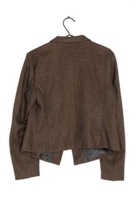 Blazer marron texturé avec un col structuré suspendu à un cintre noir, vu de dos sur un fond blanc.