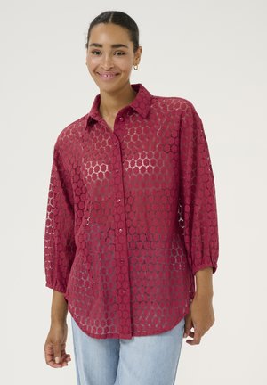 Burgundy lace shirt with a button-down collar, 3/4 sleeves, and a circular pattern, featuring a relaxed fit and lightweight texture.