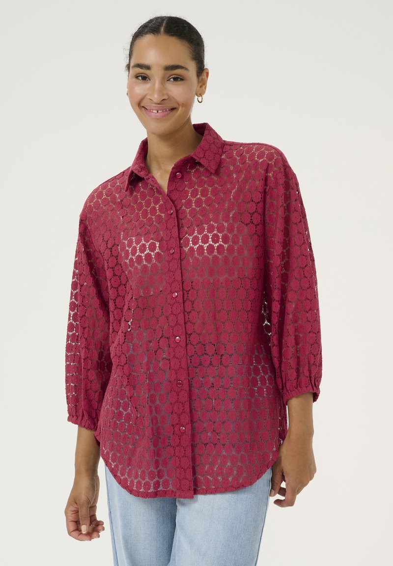 Burgundy lace shirt with a button-down collar, 3/4 sleeves, and a circular pattern, featuring a relaxed fit and lightweight texture.