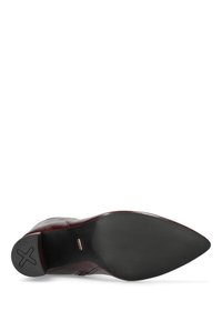 Burgunderfarbene Leder Schuhe mit spitzem Zehenbereich, glatter Textur und einer schwarzen Gummisohle, die ein Kreuzmuster für besseren Grip aufweist.