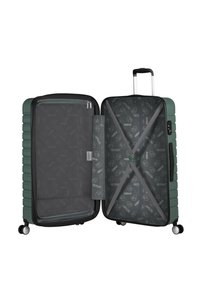 Maleta rígida verde con un sistema de correas elásticas en el interior y un bolsillo con cremallera. Acabado texturizado con forro en gris claro y ruedas.