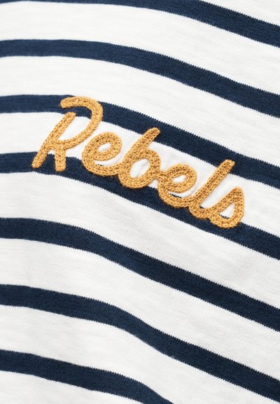 Ριγέ μπλουζάκι με οριζόντιες ρίγες σε ναυτικό μπλε και λευκό, με ανάγλυφη κεντημένη επιγραφή «Rebels» σε χρυσή κλωστή στο πάνω αριστερό μέρος.