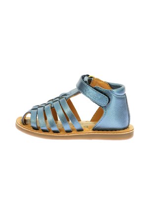 Sandalia de cuero metálico azul con múltiples tiras horizontales, diseño abierto en la punta, tirante de Velcro en el tobillo y suela color tostado.