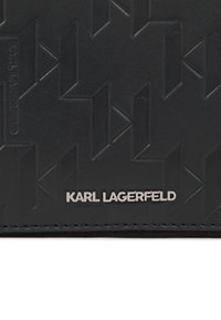 Fekete bőr pénztárca, textúrált geometrikus mintával és ezüst színű "KARL LAGERFELD" logóval. Kompakt dizájn, egyedi kiegészítőkkel.