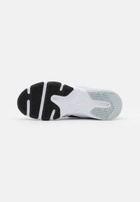 Podeszwa buta z mieszanką czarnej i białej gumy, z geometrycznymi wzorami bieżnika. Krzywa konstrukcja z wyraźną podeszwą środkową.