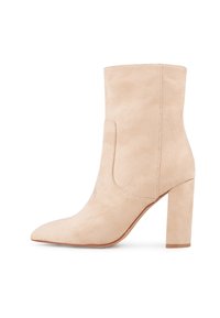Bottine beige en daim avec un bout pointu, un talon bloc et un détail de couture minimaliste. Texture lisse et silhouette élégante.