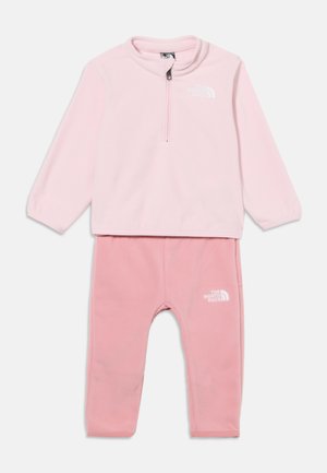 Svetloružový detský fleecový komplet s dlhým rukávom a vreckovým zipsom a vhodnými nohavicami, oba s bielym logom The North Face.