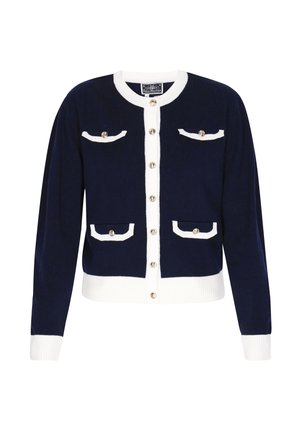 Tengerészkék kardigán fehér szegéllyel, arany gombokkal az elülső részen és négy díszzsebfedőn, bordázott mandzsettákkal és szegéllyel.