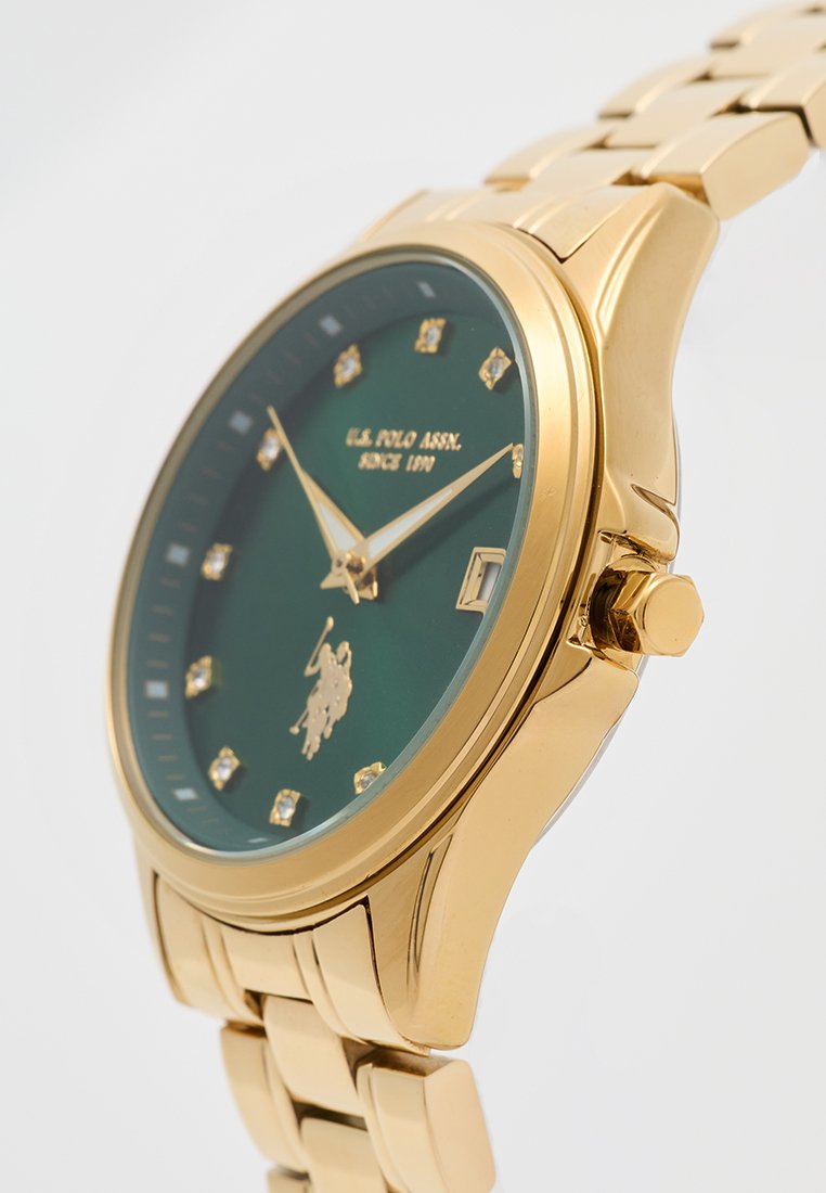 Goldfarbene U.S. Polo Assn. Armbanduhr mit grünem Ziffernblatt, Diamant-Stundenmarkierungen, goldenen Zeigern, Datumsanzeige und Metallband.