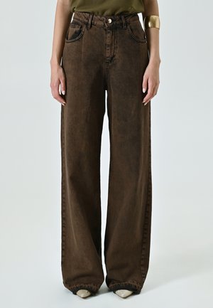 Brown wide-leg denim pants with a high waist, faded texture, and two front pockets. Featuring a button closure and stitching details.