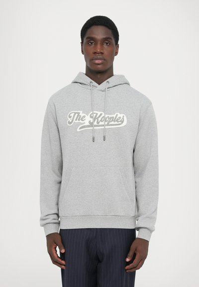 Gray hoodie with a front kangaroo pocket, drawstring hood, and large white script logo "The Kooples." Features ribbed cuffs and hem.
