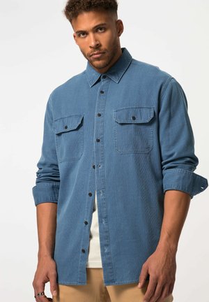Blue denim shirt featuring a button-up design, two chest pockets, contrast buttons, and rolled-up sleeves with a textured fabric finish.