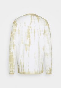 Long-sleeve shirt in white with beige tie-dye pattern. Soft cotton material, crew neck, and fitted cuffs. No visible branding or graphics.