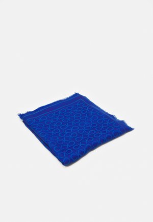 Złożony niebieski szalik z powtarzającym się wzorem logo CK i lekko postrzępionymi krawędziami na jednolitym białym tle.