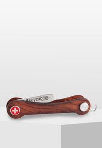 Kompakt multitool med ett trähus och blad i rostfritt stål, med ett rött schweiziskt korssymbol och en silverfärgad fästring.