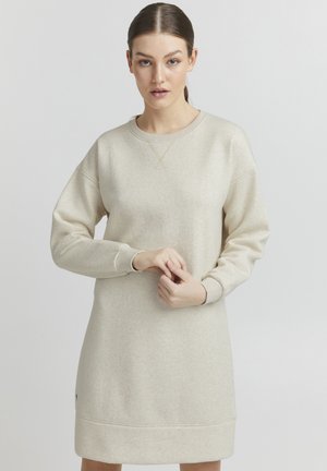 Beige sweatshirtklänning med rundad hals, långa ärmar och ribbade muddar. Har en mjuk yta och en kontrasterande nederkant.