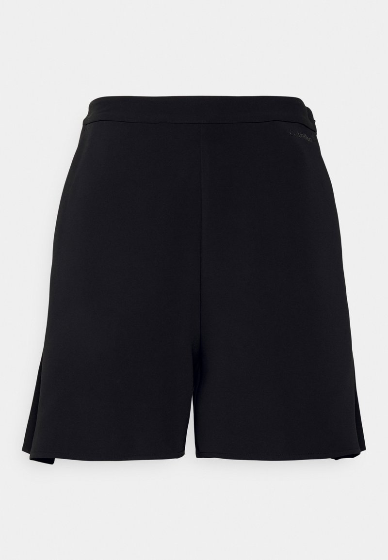 Shorts noirs jusqu'aux genoux avec une ceinture plate et des fentes latérales discrètes, présentant un tissu lisse et uni à l'avant.