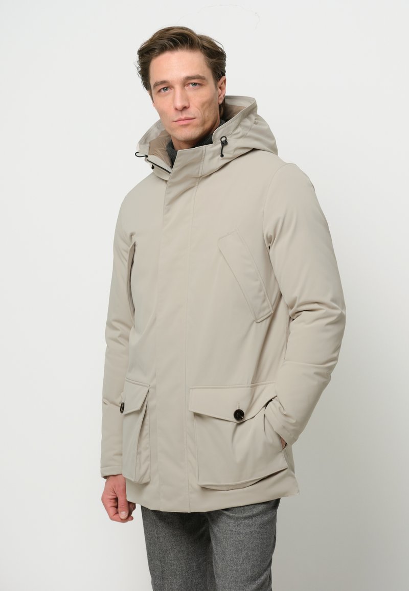 Beżowa kurtka wodoodporna z kapturem, zamkiem i zapięciem na napy, bocznymi kieszeniami i minimalistycznym designem; gładka tekstura z subtelnym połyskiem.