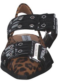 Leopard print flat shoe with a black patent leather strap featuring silver grommets and a side buckle for fastening.